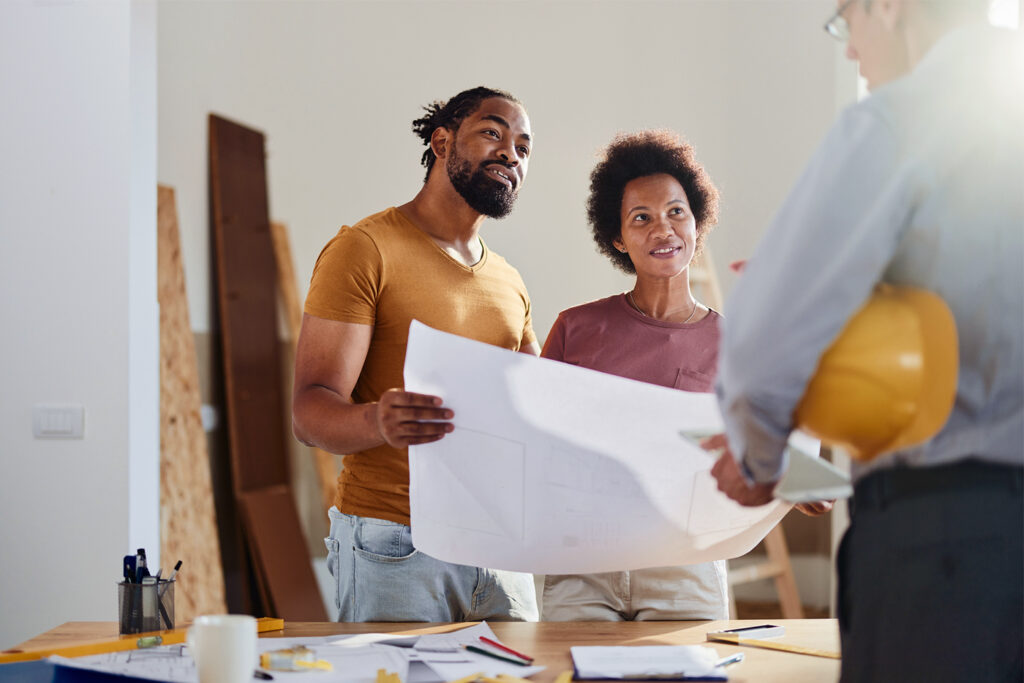 Happy black couple talking to real estate agent in the apartment.