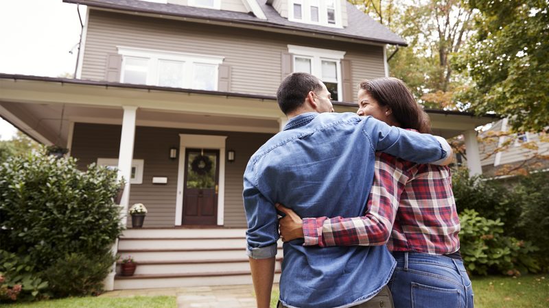 Rear View Of Loving Couple Walking Towards House