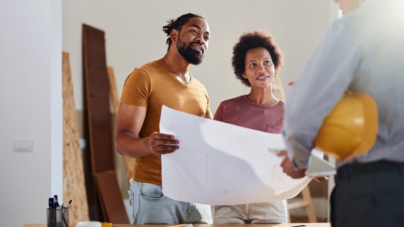 Happy black couple talking to real estate agent in the apartment.